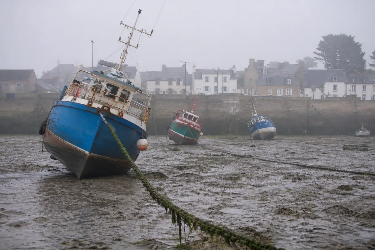 Bateaux de pêche posés sur la vase d&rsquo;un port breton à marée basse de fort coefficient