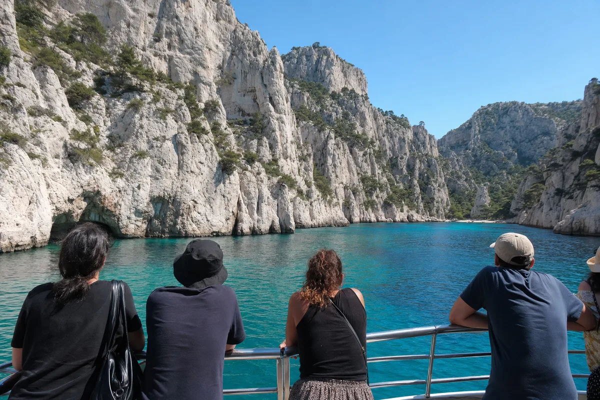 Passagers sur le pont d&rsquo;une vedette de promenade longeant des falaises calcaires
