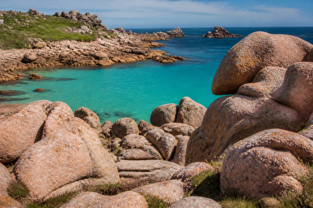 Chaos de rochers de granit rose au bord d&rsquo;une eau turquoise en Bretagne